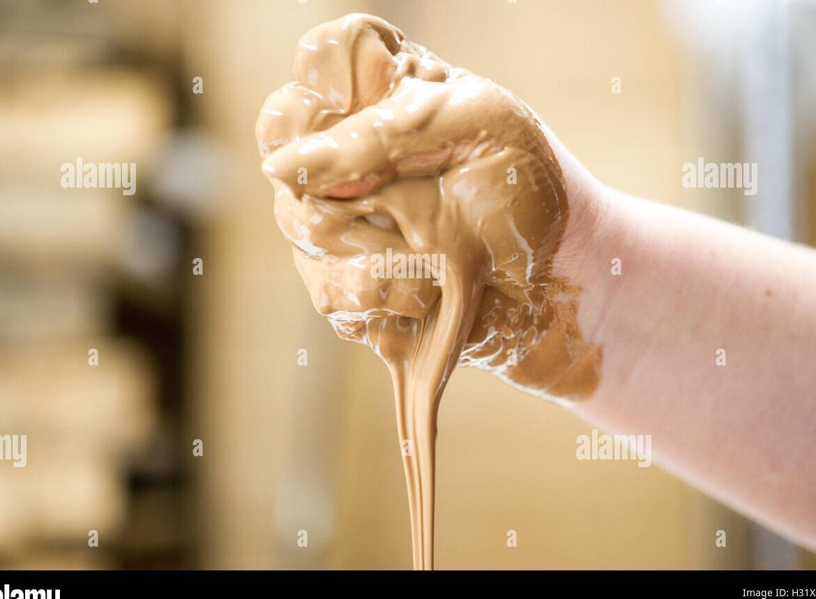 manos cubiertas de chocolate negro derretido