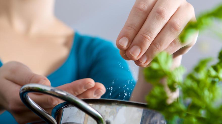 manos quitando sal de un plato