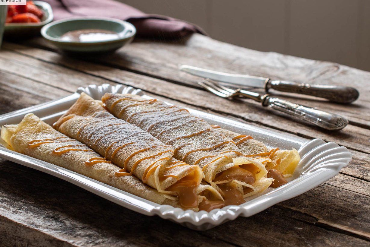 un plato de panqueques con dulce de leche