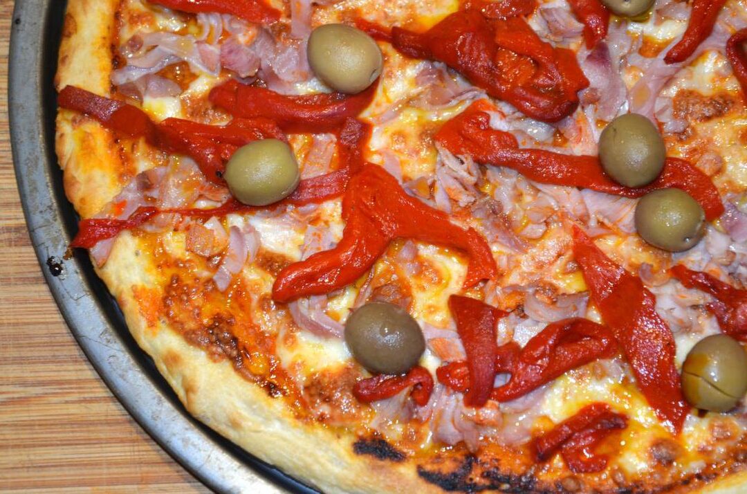 una pizza argentina cubierta de jamon y morron